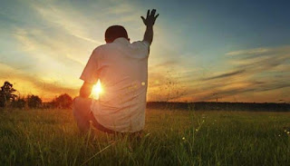 Don de fe: Un hombre con sus manos levantadas hacia el sol