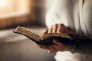Parábolas en la Biblia. Persona sosteniendo la Biblia abierta en su mano